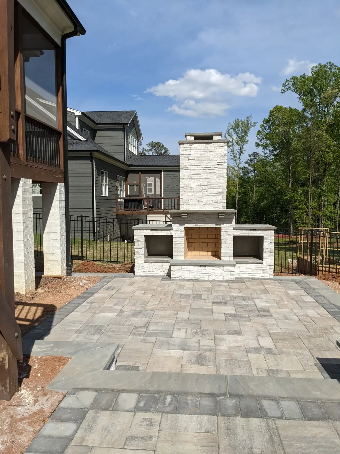 Stacked stone outdoor fireplace with wood-storage niches on a paver patio