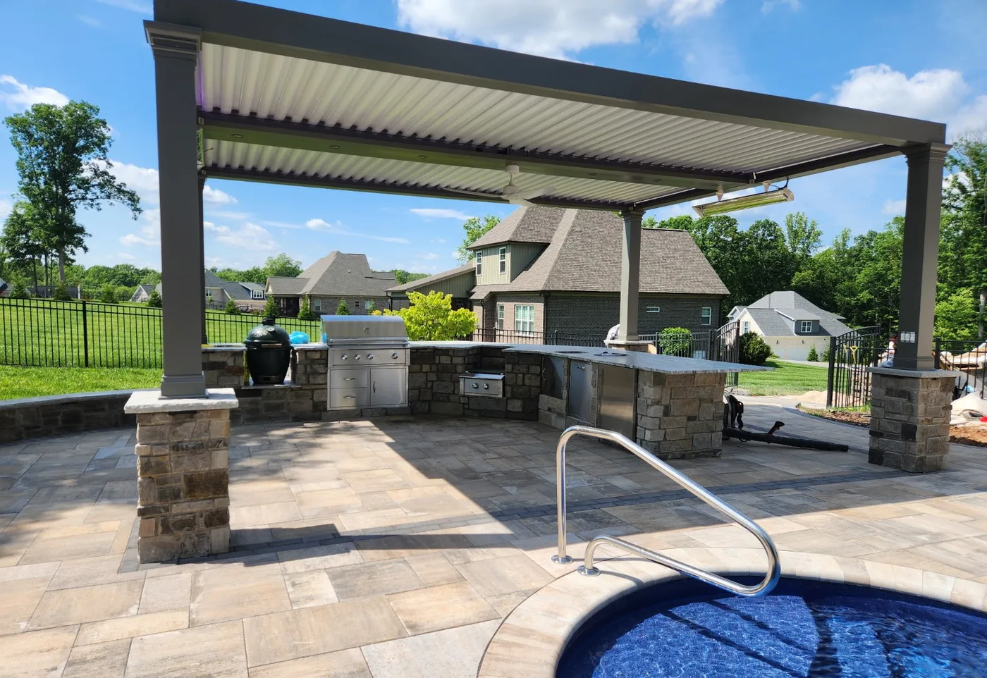 Finished outdoor kitchen and pergola with stone bar and pool