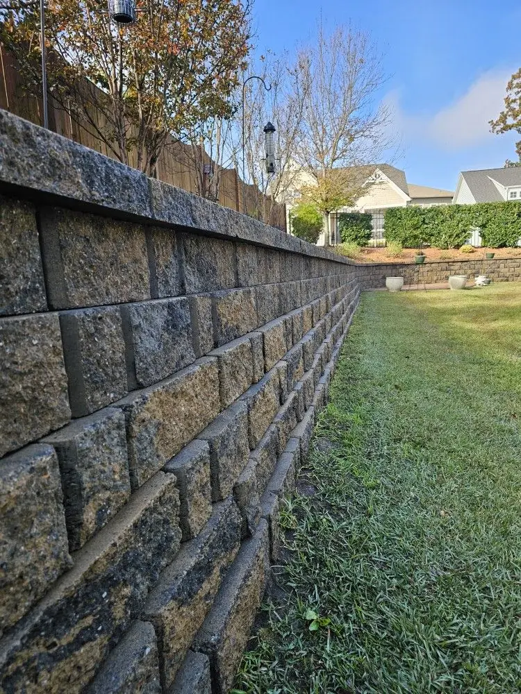 Structural block retaining wall along a residential backyard property line