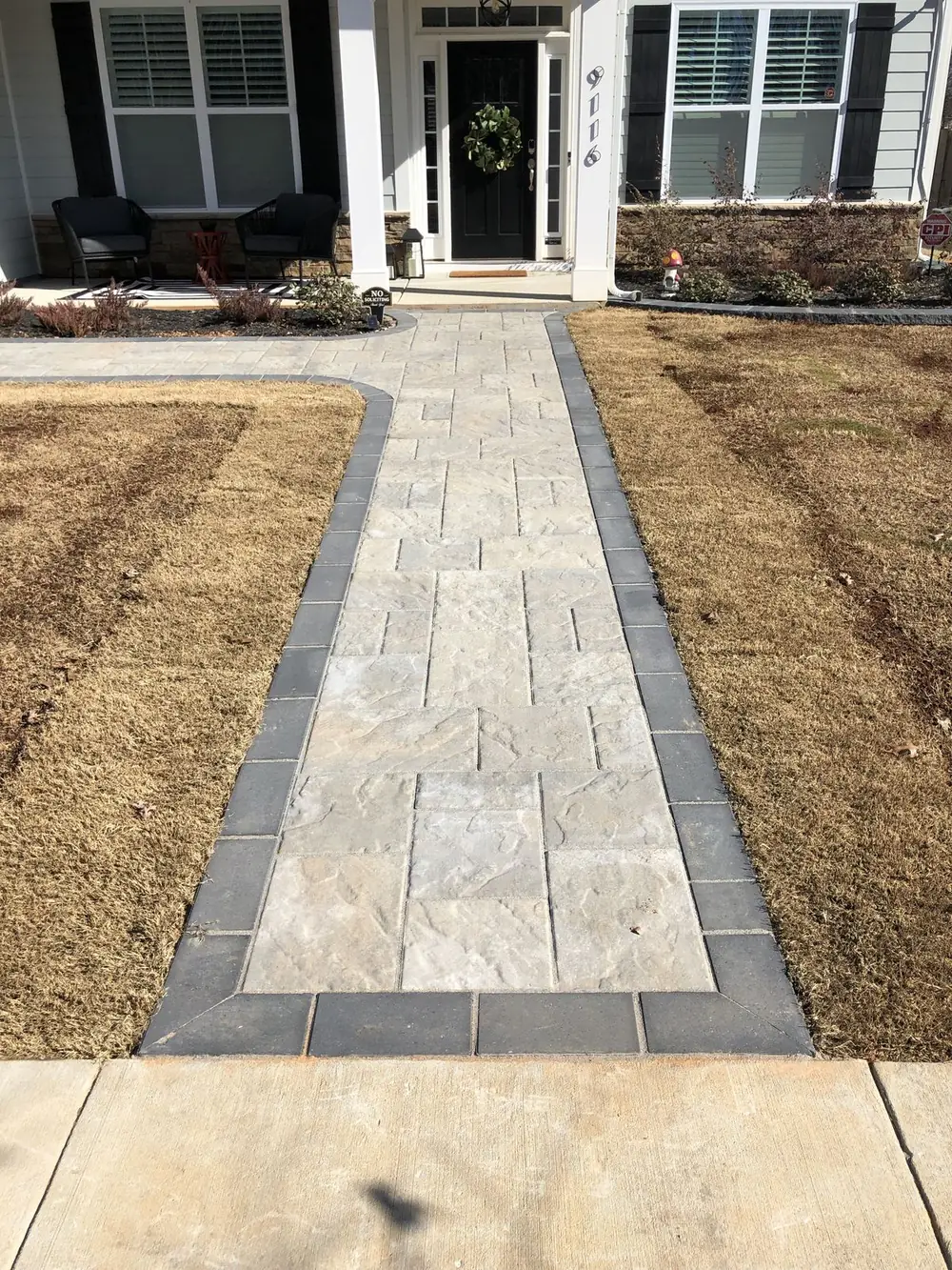 Paver walkway with contrasting border leading to a home's front entrance