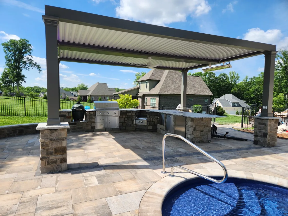 Built-in outdoor kitchen with stone counters on a finished patio